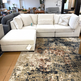 Ashley Furniture Pebblebrook 3-piece sectional sofa with ottoman, featuring plush fabric and modern design, shown in a living room setting.