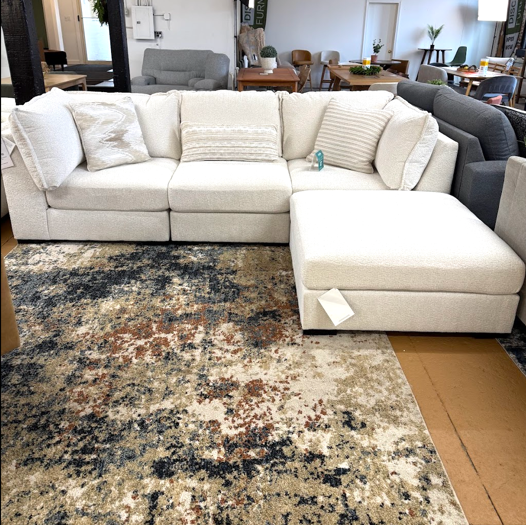 Ashley Furniture Pebblebrook 3-piece sectional sofa with ottoman, featuring plush fabric and modern design.
