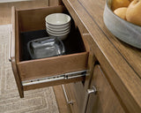 Ashley Furniture Cabalynn dining server with wood finish and storage drawers, perfect for dining room organization and style.