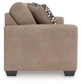 Ashley Furniture Triston-Peaks sleeper sofa with beige fabric, including seating and a fold-out bed, shown from a side angle.