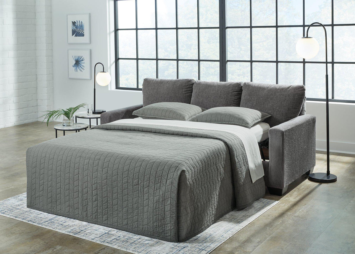 Ashley Furniture Rannis sofa sleeper with beige upholstery, featuring a fold-out bed and plush seating for versatile living space.