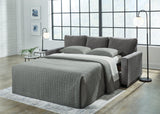 Ashley Furniture Rannis sofa sleeper with beige upholstery, featuring a fold-out bed and plush seating for versatile living space.