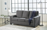 Ashley Furniture Rannis Sleeper Sofa shown in a stylish living room setting, featuring a modern design with plush cushions and fabric upholstery.