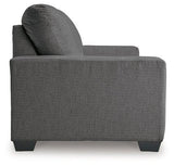 Ashley Furniture Rannis sofa sleeper with plump cushions and neutral fabric, designed for comfortable sitting and sleeping.