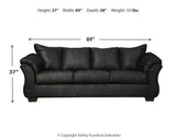 Ashley Furniture Darcy sofa showing plush beige upholstery, wide armrests, and cushioned back in a modern living room setting.