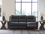 Ashley Furniture Mackmenville reclining sofa shown in an open position with plush cushions and dark upholstery on a modern living room setting.