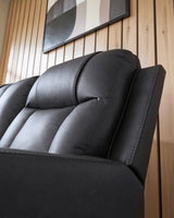 Ashley Furniture Mackmenville reclining sofa with plush fabric and padded armrests, shown in a detailed close-up image.