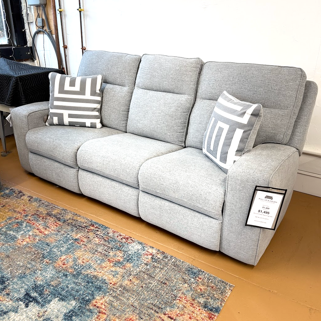 Ashley Furniture Biscoe Power Reclining Sofa with plush cushions and reclining feature, shown in a modern living room setting.