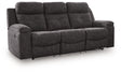 Ashley Furniture Brysonview reclining sofa with plush cushions, dark upholstery, and a modern design viewed from an angle.