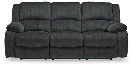 Ashley Furniture Draycoll power reclining sofa with plush cushions and reclining features, shown in a modern living room setting.