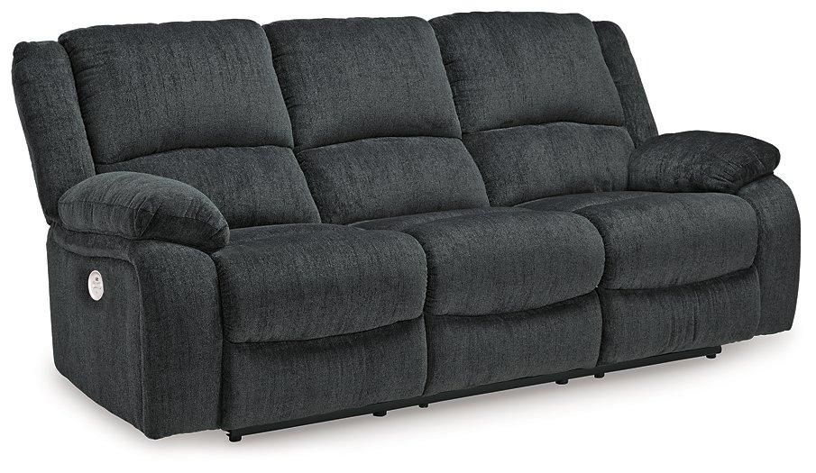 Ashley Furniture Draycoll power reclining sofa with plush cushions and dark upholstery, shown in a modern living room setting.