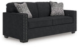 Ashley Furniture Jasmine Peaks sofa with plush beige upholstery and modern design, shown from an angled view.