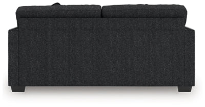 Ashley Furniture Jasmine Peaks sofa with plush cushions and wooden legs, shown from the back in a stylish living room setting.