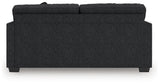 Ashley Furniture Jasmine Peaks sofa with plush cushions and wooden legs, shown from the back in a stylish living room setting.