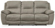 Ashley Furniture Next-Gen Gaucho Reclining Sofa showing plush fabric, padded armrests, and reclining sections in a modern living room setting.