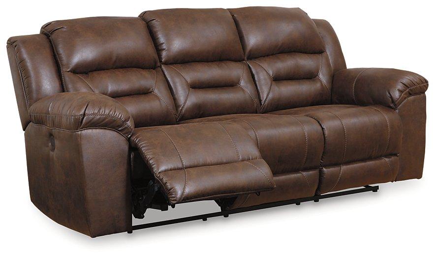 Ashley Furniture Stoneland Power Reclining Sofa with plush cushions, dark fabric upholstery, and built-in recline mechanisms.