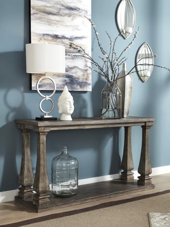 Ashley Furniture Johnelle sofa table with a sleek wooden finish and modern design, perfect for living room decor.