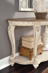 Ashley Furniture Realyn sofa table with a sleek wooden surface and modern design, ideal for living room decor.