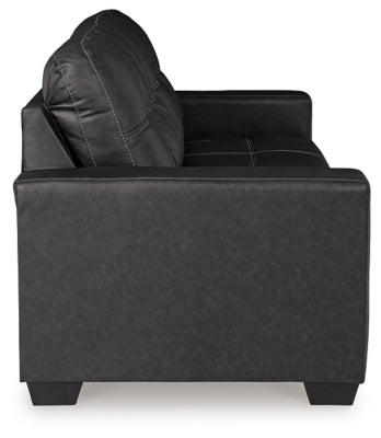 Ashley Furniture Barlin Mills sofa with plush fabric and cushioned armrests, shown from the side in a stylish living room setting.