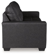 Ashley Furniture Barlin Mills sofa with plush fabric and cushioned armrests, shown from the side in a stylish living room setting.