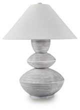 Ashley Furniture Brickdon table lamp with a sleek base and fabric shade, perfect for enhancing home decor.