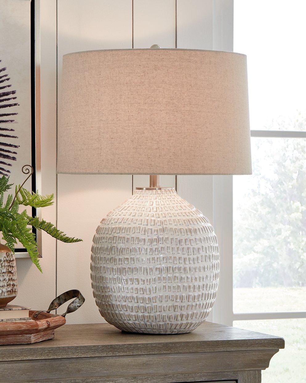 Ashley Furniture Jamon table lamp with a sleek design, featuring a fabric shade and modern base, ideal for living room decor.
