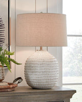 Ashley Furniture Jamon table lamp with a sleek design, featuring a fabric shade and modern base, ideal for living room decor.