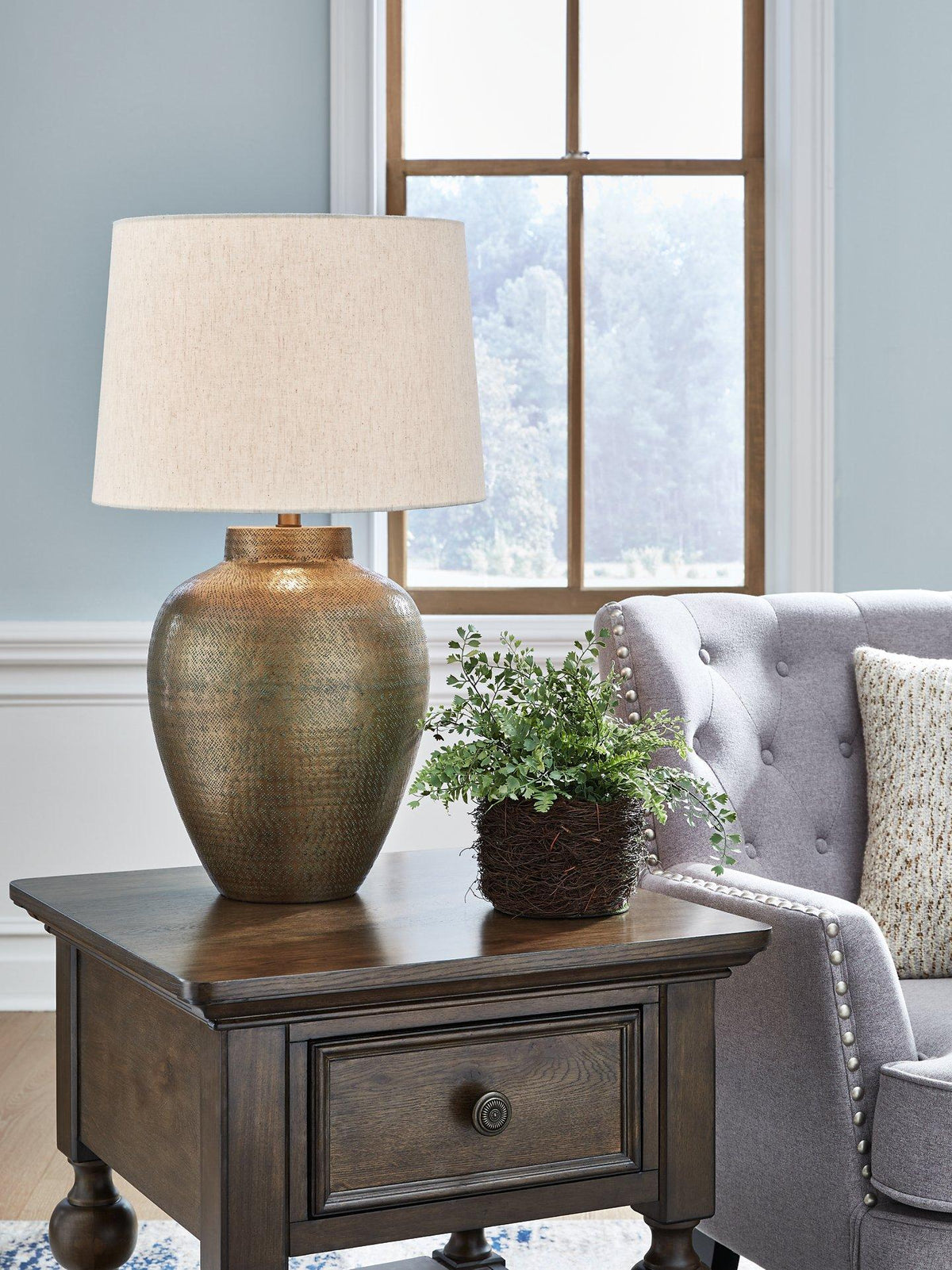 Madney table lamp by Ashley Furniture featuring a sleek base and a fabric shade, perfect for modern bedroom or living room decor.
