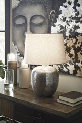 Ashley Furniture Magalie table lamp with a sleek base and fabric shade, ideal for adding ambient lighting to a living space.