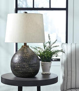 Maire table lamp by Ashley Furniture featuring a modern design with a sleek base and fabric shade, perfect for living room lighting.
