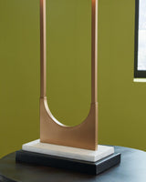 Malana Table Lamp by Ashley Furniture featuring a modern design with a fabric shade and wooden base on a side table.