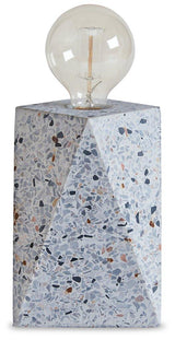 Maywick table lamp by Ashley Furniture featuring a sleek design with a fabric shade and modern base, ideal for bedside or living room.