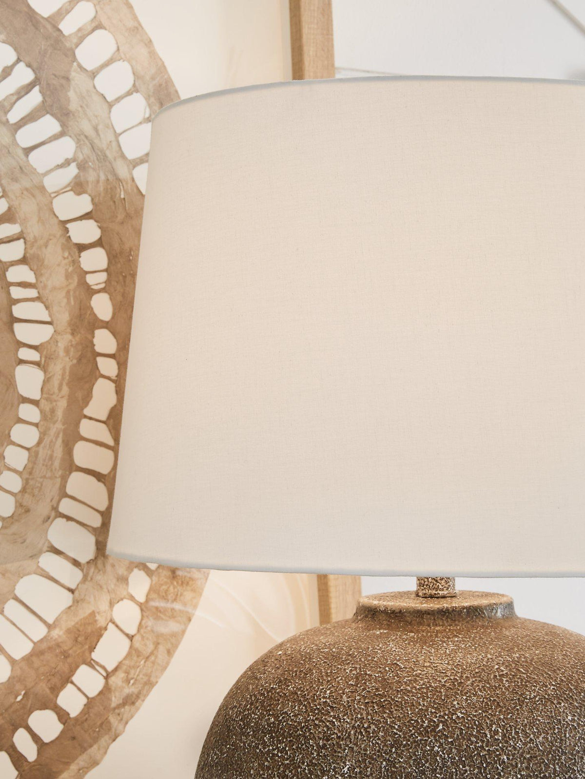 Neavesboro table lamp by Ashley Furniture featuring a classic cylindrical shade and decorative base for cozy lighting.