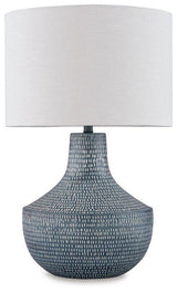 Schylarmont Table Lamp by Ashley Furniture featuring a sleek ceramic base and fabric shade on a wooden bedside table