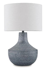 Ashley Furniture Schylarmont table lamp with a classic base and fabric shade, placed on a wooden side table.