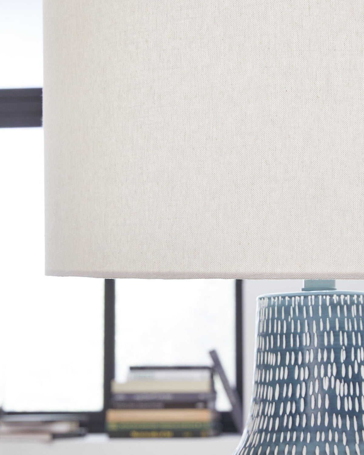 Schylarmont table lamp by Ashley Furniture with a classic design, featuring a fabric shade and wooden base on a side table.