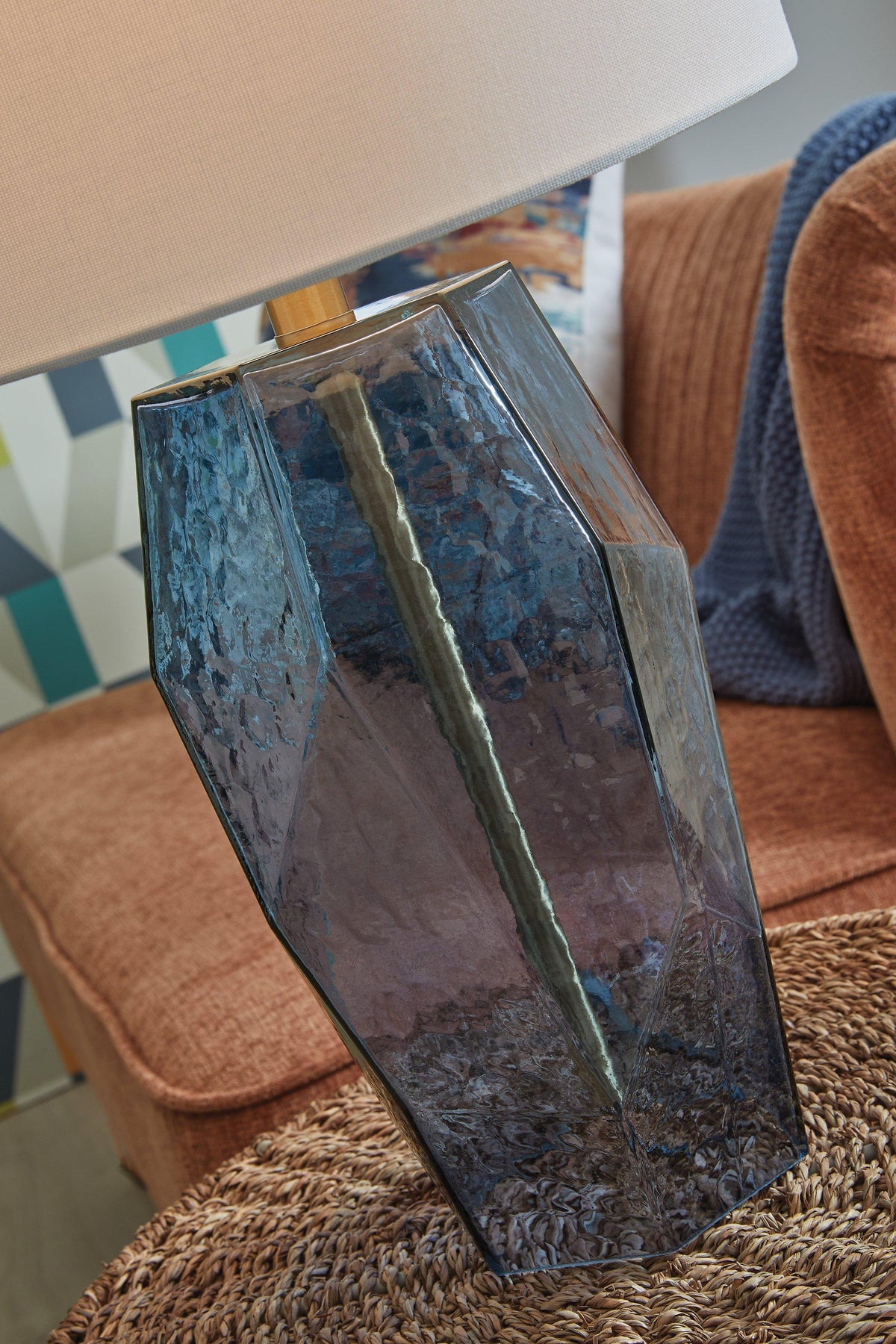 Tallow Ashley Furniture table lamp with a ceramic base and fabric shade, positioned on a wooden side table in a cozy living room.