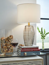 Ashley Furniture Taylow Table Lamp with a sleek, modern design and a neutral fabric lampshade on a wooden base.