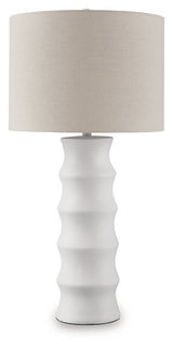 Ashley Furniture Veraleigh table lamp with a beige fabric shade and a dark bronze base, sitting on a wooden side table.