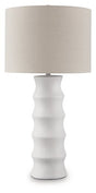 Ashley Furniture Veraleigh table lamp with a beige fabric shade and a dark bronze base, sitting on a wooden side table.