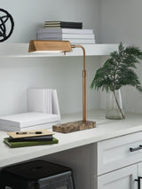 Yafe Ashley Furniture table desk lamp with a sleek modern design and a white lampshade on a wooden desk.