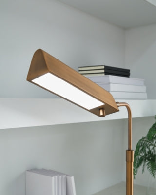 Yafe Ashley Furniture table desk lamp with a sleek design and neutral-colored shade on a wooden desk.