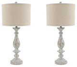 Pair of Ashley Furniture Bernadate table lamps with beige fabric shades and ceramic bases on a wooden surface.