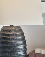 Pair of Ashley Furniture Caronick table lamps with beige fabric shades and dark wood bases, ideal for bedside or living room decor.