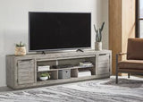 Ashley Furniture Naydell 92-inch TV stand with open shelving and storage compartments for living room entertainment setup.