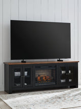 Wildenauer 76-inch TV stand with electric fireplace by Ashley Furniture, featuring a modern wood finish and built-in fireplace insert.