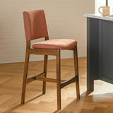 Article MCM-style upholstered barstool in orange and walnut finish, featuring a padded seat and sleek wooden legs.